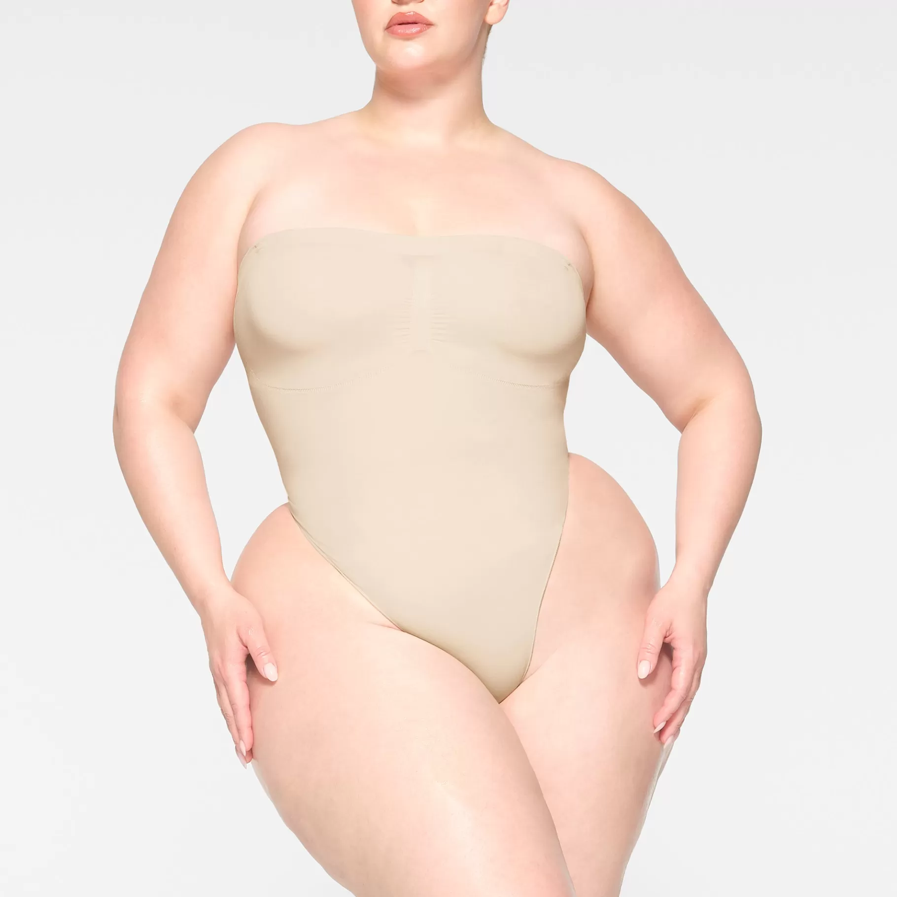 Skims seamless sculpt*SEAMLESS SCULPT STRAPLESS THONG BODYSUIT | SAND